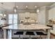 Modern kitchen featuring a large island with granite countertops and seating, stylish pendant lights, and stainless steel appliances at 919 Olmsted Ln, Johns Creek, GA 30097