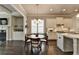 Bright open kitchen and dining area featuring an island, stainless appliances, white cabinets and hardwood floors at 919 Olmsted Ln, Johns Creek, GA 30097