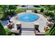 Overhead view of a blue splash pad surrounded by benches and tables with umbrellas in a green community area at 919 Olmsted Ln, Johns Creek, GA 30097