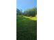 A spacious, green lawn bordered by mature trees under a sunny, clear blue sky at 144 Wiley Dr, Douglasville, GA 30134