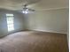 Bedroom with neutral paint, carpet flooring, ceiling fan with light and large window at 5340 Forest Pl, Stone Mountain, GA 30088
