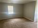Neutral bedroom featuring a window bringing in natural light and carpeted flooring at 5340 Forest Pl, Stone Mountain, GA 30088