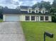 Exterior view of home with two-car garage, well-maintained lawn, and traditional design at 5340 Forest Pl, Stone Mountain, GA 30088