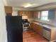 Kitchen with stainless steel appliances, wood cabinets, and laminate flooring at 5340 Forest Pl, Stone Mountain, GA 30088