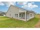Backyard view of the home, including the covered patio and green lawn at 6908 Winchester Pl, Fairburn, GA 30213