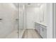 Bright bathroom featuring a glass shower, double vanity with gray cabinets, and light wood-look flooring at 6908 Winchester Pl, Fairburn, GA 30213