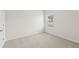 Cozy bedroom with neutral carpet, white walls, and a bright window view at 6908 Winchester Pl, Fairburn, GA 30213