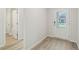 Clean and bright home entryway featuring wood grain floors, white walls, and a glass pane front door at 6908 Winchester Pl, Fairburn, GA 30213