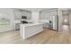 Modern kitchen featuring an island, stainless steel appliances, and light gray cabinets at 6908 Winchester Pl, Fairburn, GA 30213