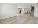 Open concept living area with stairs, kitchen, wood grain flooring, and neutral walls at 6908 Winchester Pl, Fairburn, GA 30213