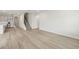 Spacious living room featuring wood grain flooring, neutral walls, and open access to the staircase and kitchen at 6908 Winchester Pl, Fairburn, GA 30213