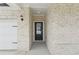 Close-up of the front door, flanked by brickwork and stylish outdoor lighting at 7760 Sheffield Ter, Fairburn, GA 30213