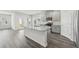 Bright kitchen with gray cabinets, island, stainless steel appliances and wood floors at 7760 Sheffield Ter, Fairburn, GA 30213