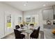 Bright breakfast nook with dining table, gray cabinets, wood floors, and backyard view at 7760 Sheffield Ter, Fairburn, GA 30213