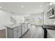 Open kitchen with island, stainless appliances, gray cabinets, and wood-style floors at 7760 Sheffield Ter, Fairburn, GA 30213