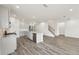 Open kitchen with island, stainless appliances, gray cabinets, and wood-style floors at 7760 Sheffield Ter, Fairburn, GA 30213