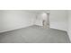 Open living room with neutral gray carpet and open access to staircase at 7760 Sheffield Ter, Fairburn, GA 30213