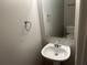 Small powder room with a pedestal sink, large mirror, and neutral paint at 1247 To Lani Farm Rd, Stone Mountain, GA 30083