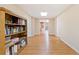 Hallway with hardwood floors, bookshelf, and view of a room ahead at 132 Copper Hills Dr, Canton, GA 30114