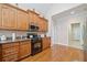 Well-lit kitchen with dark appliances, granite countertops, and wooden cabinets at 132 Copper Hills Dr, Canton, GA 30114