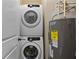 Convenient laundry room featuring a stacked washer and dryer unit next to a hot water heater at 1832 Gordon Ne Mnr, Atlanta, GA 30307