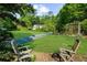 Spacious backyard featuring a lush lawn, mature trees, lounge chairs, and a garden trellis at 45 Michelle Ne Cir, Atlanta, GA 30342
