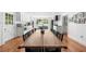 Open-concept dining area with a long table, connecting to a modern kitchen with white cabinetry at 45 Michelle Ne Cir, Atlanta, GA 30342