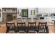 Dining area with a long wooden table, seating for many, connecting to a modern kitchen with white cabinets at 45 Michelle Ne Cir, Atlanta, GA 30342