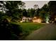 Nighttime view of the home surrounded by trees, with a driveway and subtle exterior lighting at 45 Michelle Ne Cir, Atlanta, GA 30342