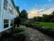 Side view of a white house with brick trim and a well maintained walkway surrounded by lush vegetation at 45 Michelle Ne Cir, Atlanta, GA 30342