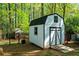 Barn style shed with modern black accents and a ramp for accessibility, set in a lush yard at 45 Michelle Ne Cir, Atlanta, GA 30342