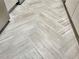 Close up of herringbone pattern gray-toned kitchen flooring with light gray cabinets on either side at 475 Mount Vernon Ne Hwy # 129C, Atlanta, GA 30328