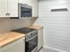 An updated kitchen featuring stainless steel appliances, butcher block counters, and a white backsplash at 475 Mount Vernon Ne Hwy # 129C, Atlanta, GA 30328