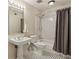 This bathroom features a classic design with a pedestal sink, black and white tile floor, and shower/tub combo at 6906 Park Ave, Atlanta, GA 30342
