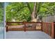 A charming outdoor deck with wooden railings offers a peaceful view of lush trees and neighborhood at 6906 Park Ave, Atlanta, GA 30342