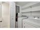 A well-organized laundry room featuring a white washer and dryer, with convenient shelving for storage at 6906 Park Ave, Atlanta, GA 30342