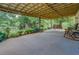 Covered back porch featuring seating, lush plants, and a serene outdoor view, perfect for relaxation at 75 Puppy Chase, Social Circle, GA 30025