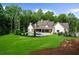 Expansive backyard featuring a pool, lush lawn, mature trees, and a covered patio area at 1084 Wrights Mill Rd, Canton, GA 30115