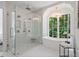 The luxury bathroom is designed with a soaking tub, glass shower, and picture window with wooded views at 1084 Wrights Mill Rd, Canton, GA 30115