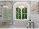 Freestanding tub sits next to a large window in the luxurious bathroom, overlooking the wooded property at 1084 Wrights Mill Rd, Canton, GA 30115