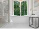 Bright bathroom featuring a modern standalone tub with view to green backyard at 1084 Wrights Mill Rd, Canton, GA 30115