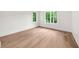 Bright bedroom with light wood floors and two windows providing views of the outside greenery at 1084 Wrights Mill Rd, Canton, GA 30115