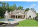 Stunning backyard featuring a custom pool, covered outdoor space and lush landscaping at 1084 Wrights Mill Rd, Canton, GA 30115