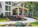 Inviting covered front porch featuring a brick base, white columns, and landscaped flower beds at 1084 Wrights Mill Rd, Canton, GA 30115