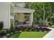 Inviting front porch with swing seating, brick accents, and lush landscaping at 1084 Wrights Mill Rd, Canton, GA 30115
