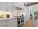 Gourmet kitchen features white cabinets, stainless steel Wolf range, and pot filler at 1084 Wrights Mill Rd, Canton, GA 30115