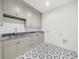 Functional laundry room featuring gray cabinetry, granite countertops, and geometric tile flooring at 1084 Wrights Mill Rd, Canton, GA 30115
