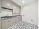 Laundry room featuring grey cabinets, marble countertops, and patterned tile floors at 1084 Wrights Mill Rd, Canton, GA 30115