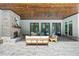 Covered outdoor patio featuring a brick fireplace and comfortable lounge furniture at 1084 Wrights Mill Rd, Canton, GA 30115