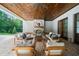 Covered patio with a brick fireplace, comfortable seating, and wood plank ceiling, ideal for outdoor entertaining at 1084 Wrights Mill Rd, Canton, GA 30115